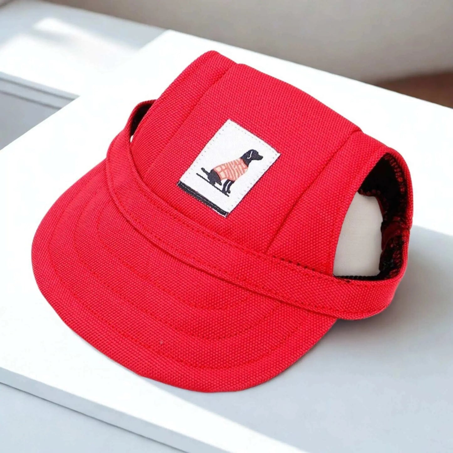 Une casquette chien rouge sur un bureau blanc.