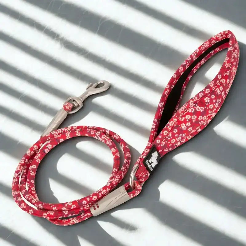 Pour chien, une laisse rouge avec motif fleur.