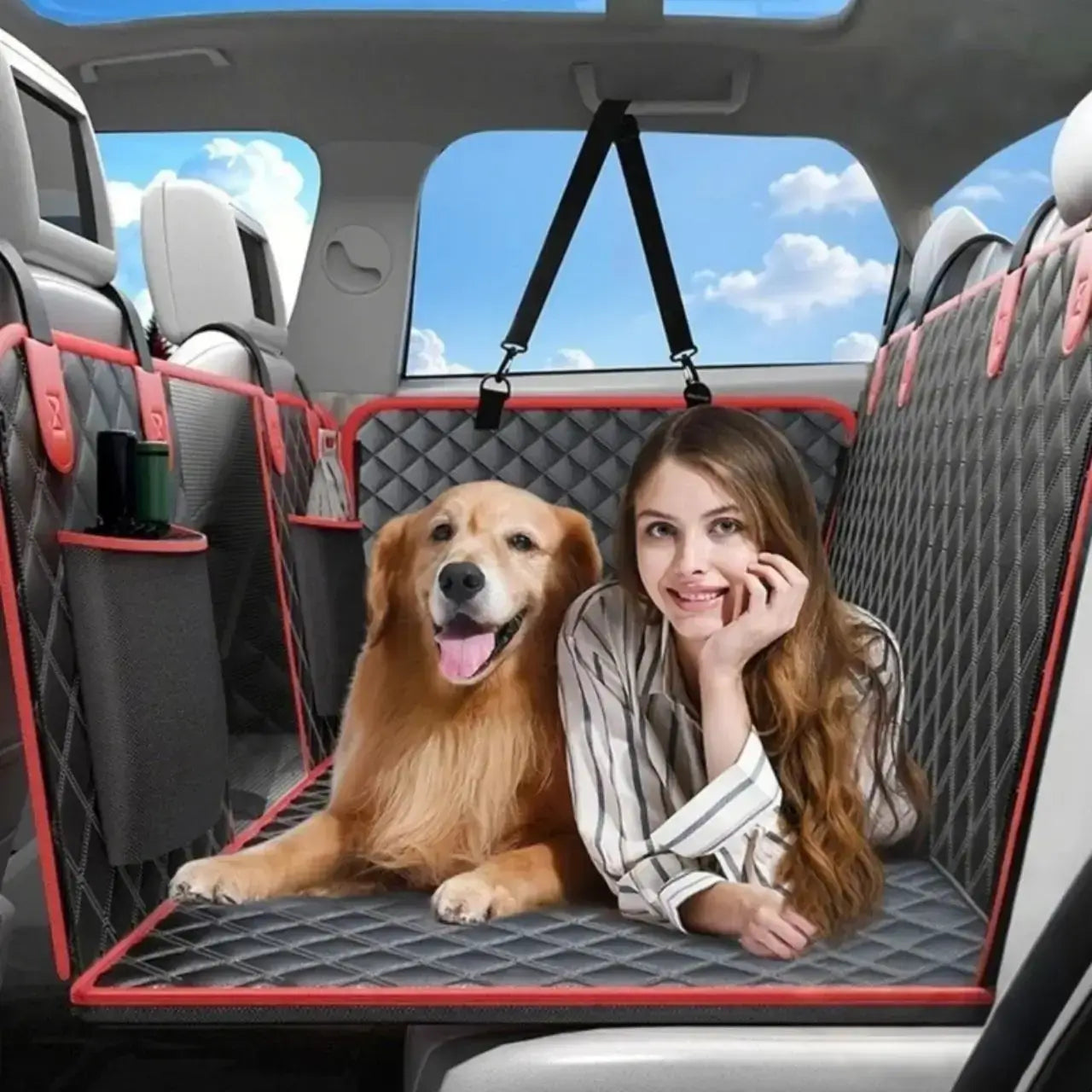 Une femme allongée avec son golden retriever sur la housse pour chien de voiture pour protection sur le siège arrière.
