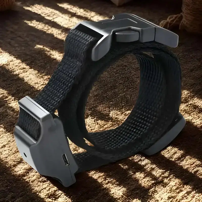 Un collier anti-aboiement noir sur un tapis.
