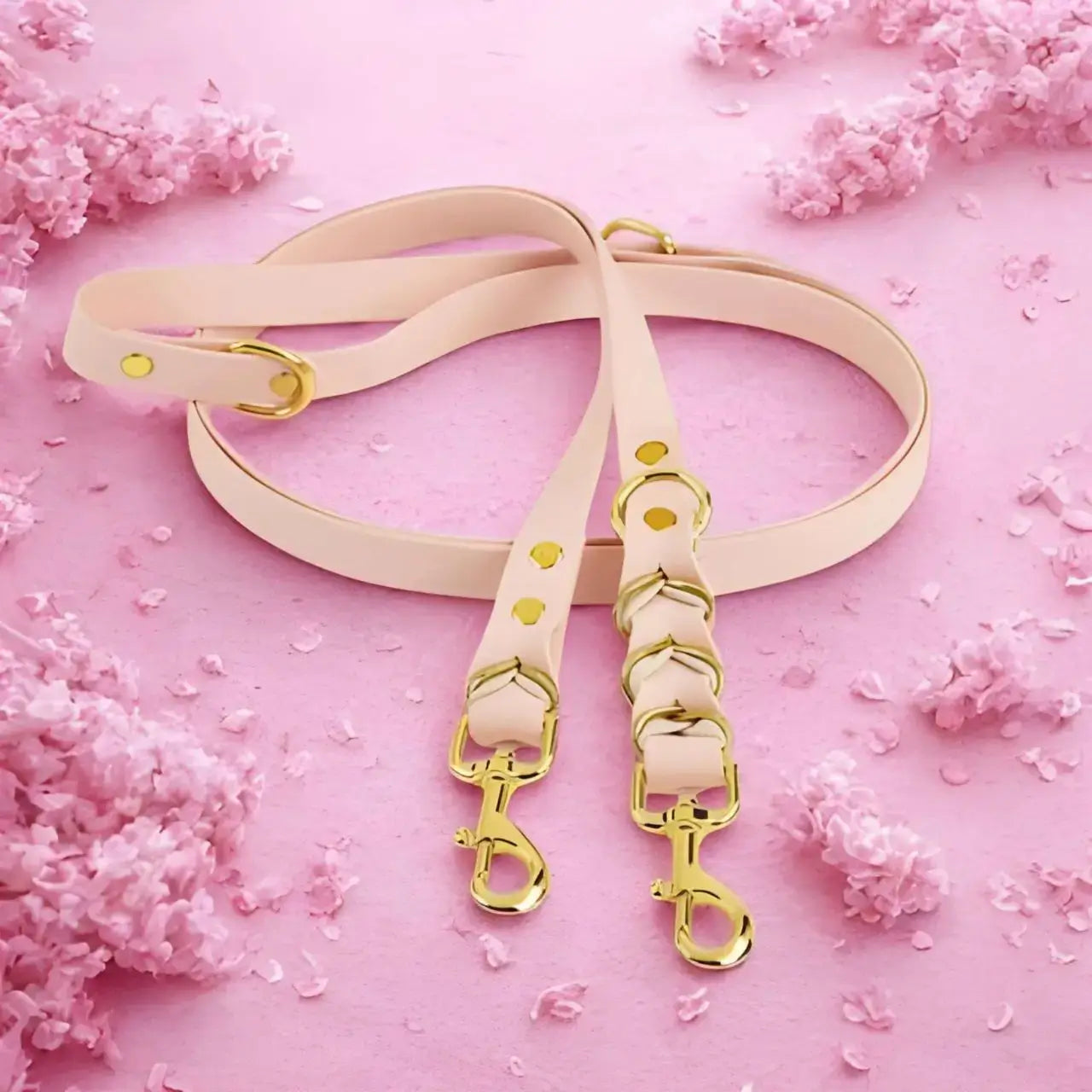 Une double laisse pour chien de couleur rose.