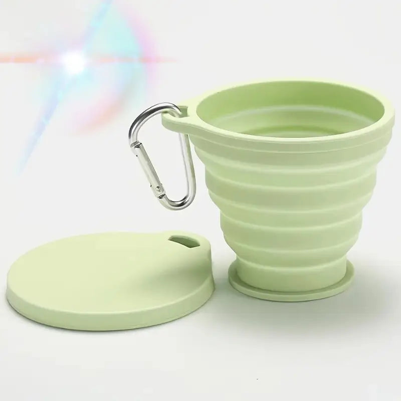 Une gamelle d'eau pour chien avec mousqueton de couleur verte.
