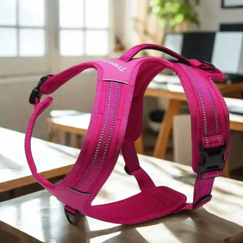 Un harnais anti-traction pour chien de couleur rose.