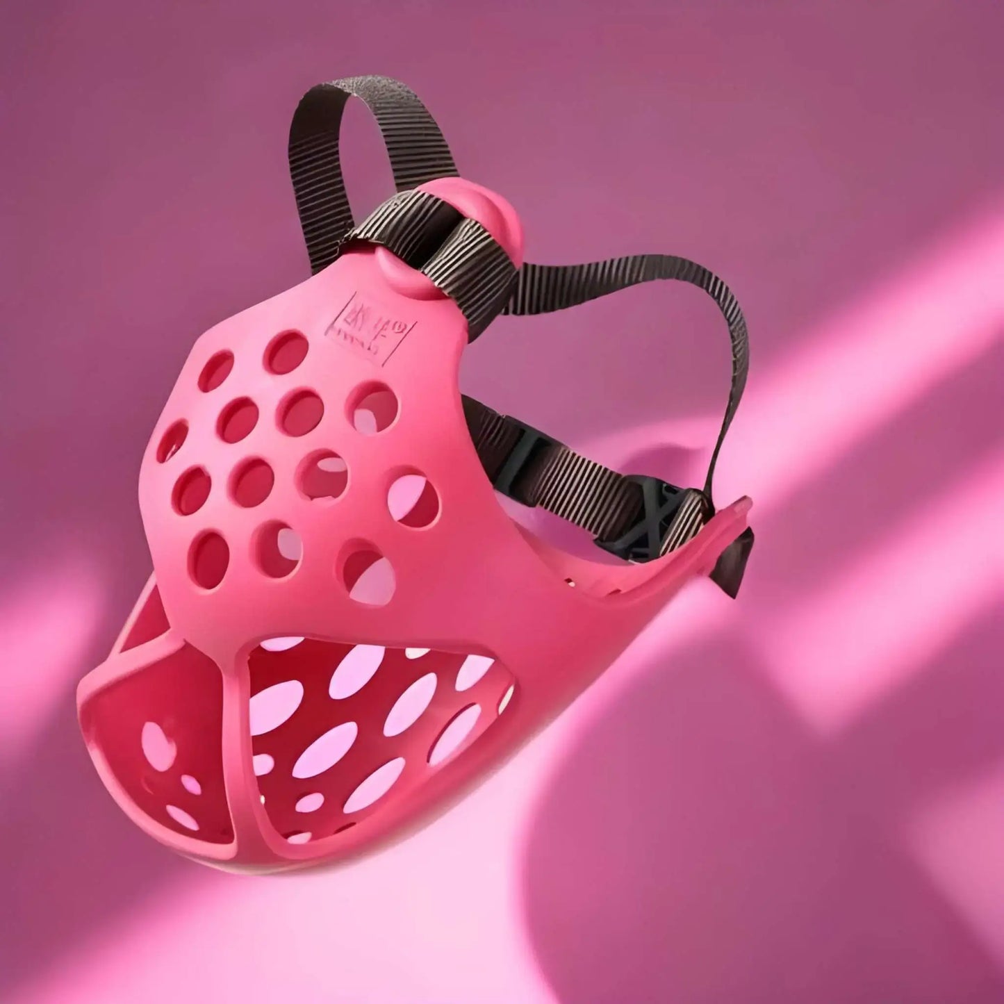 Une muselière pour bouledogue français de couleur rose.