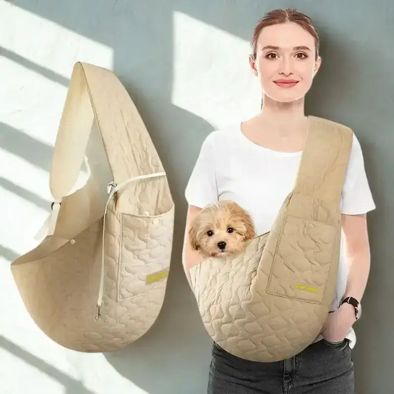 Une femme avec son caniche dans son sac bandoulière pour chien beige.