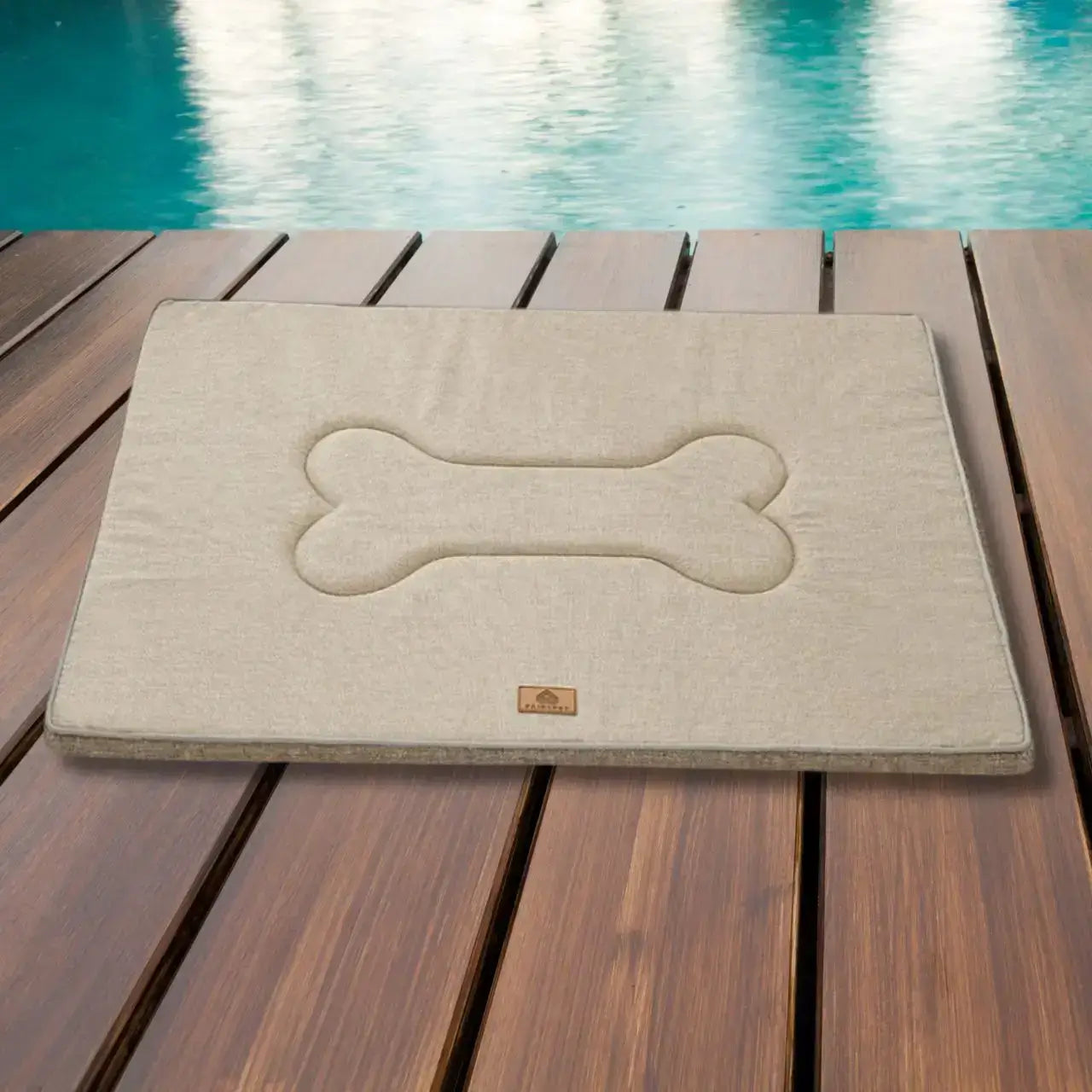 Un tapis imperméable pour chien beige sur un quai de piscine.