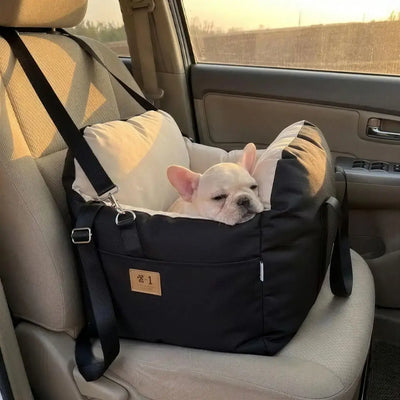 Un chiot bouledogue français se repose dans son siège d'auto pour chien.