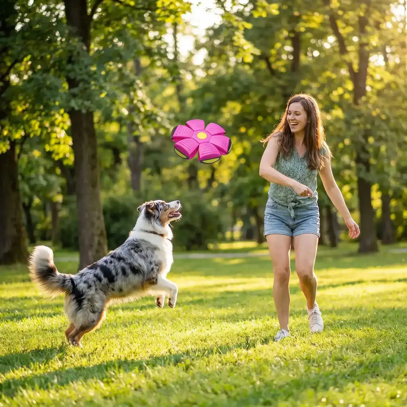 Une femme joue à lancer la balle pour chien indestructible à son berger australien au parc.