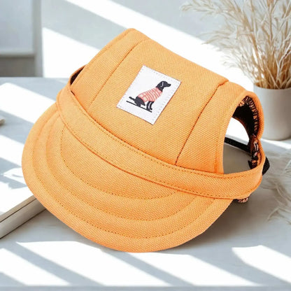 Une casquette chien jaune sur un bureau blanc avec un petit pot de fleurs. 