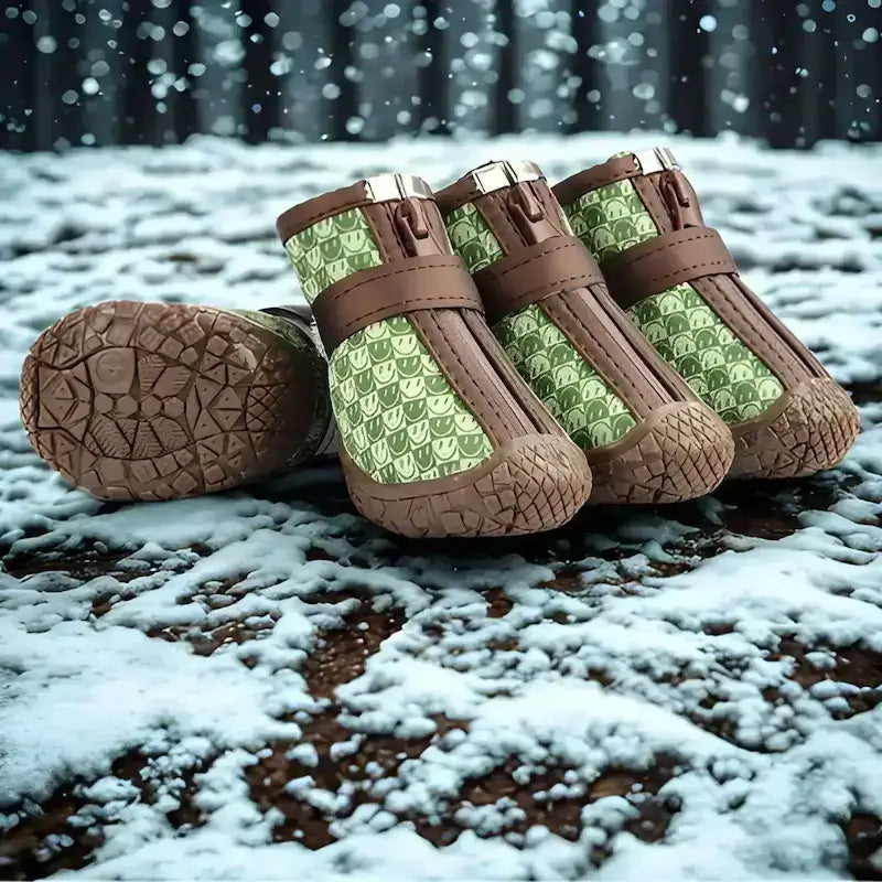 Chaussure pour chien verte à motif bonhomme sourire sur la neige.