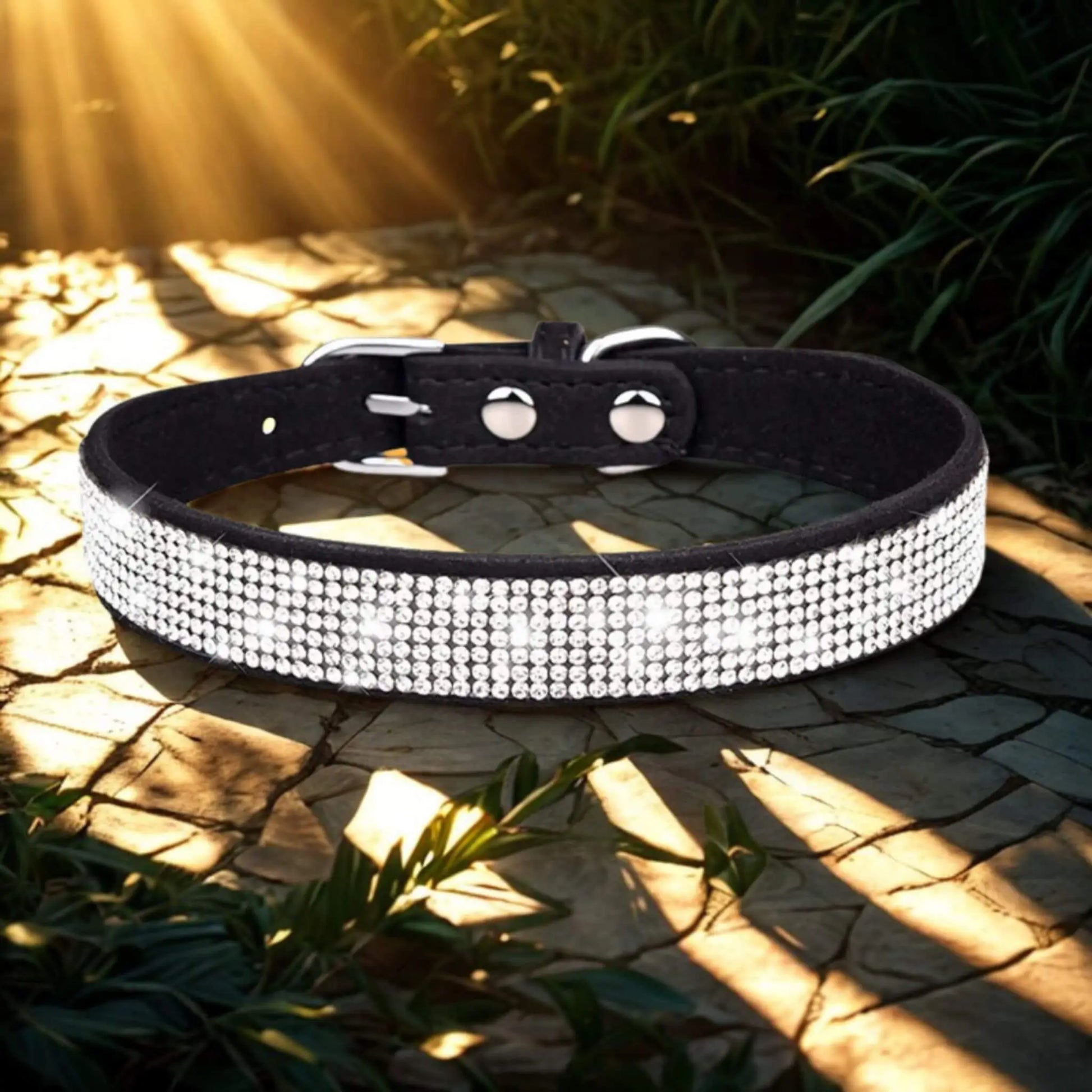 Un collier noir avec strass sur une planche avec des rayons de soleil qui se reflètent dessus.
