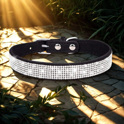 Un collier noir avec strass sur une planche avec des rayons de soleil qui se reflètent dessus.