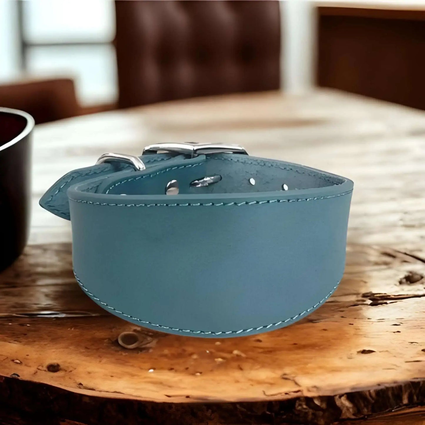 Un collier chien CouDog de couleur bleue sur une table de bois.