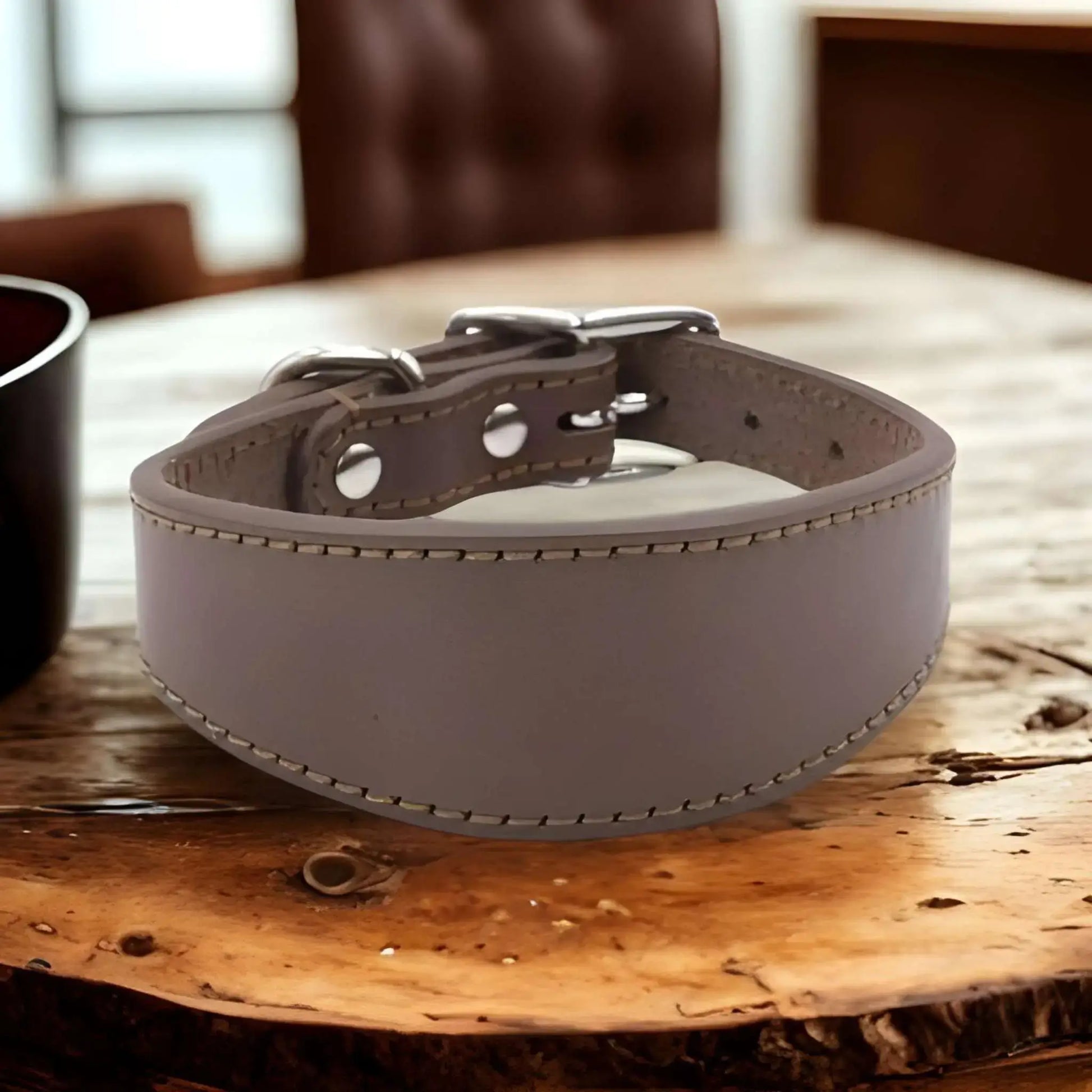 Un collier chien CouDog de couleur marron sur une table de bois.