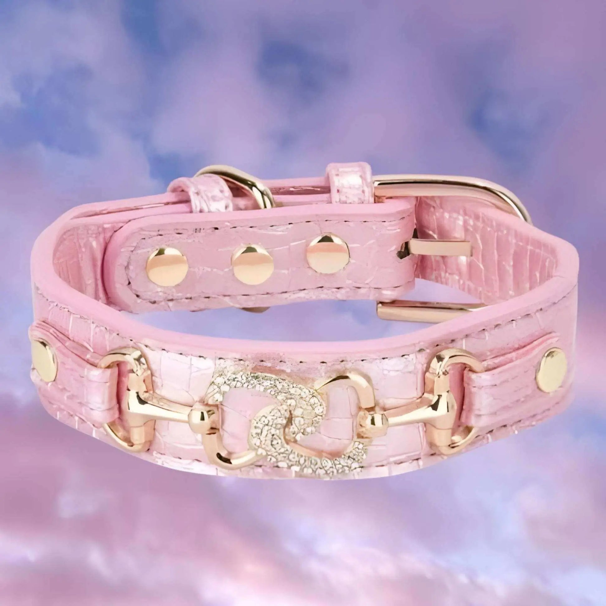 Un collier chiot rose avec ornement en métal et strass.