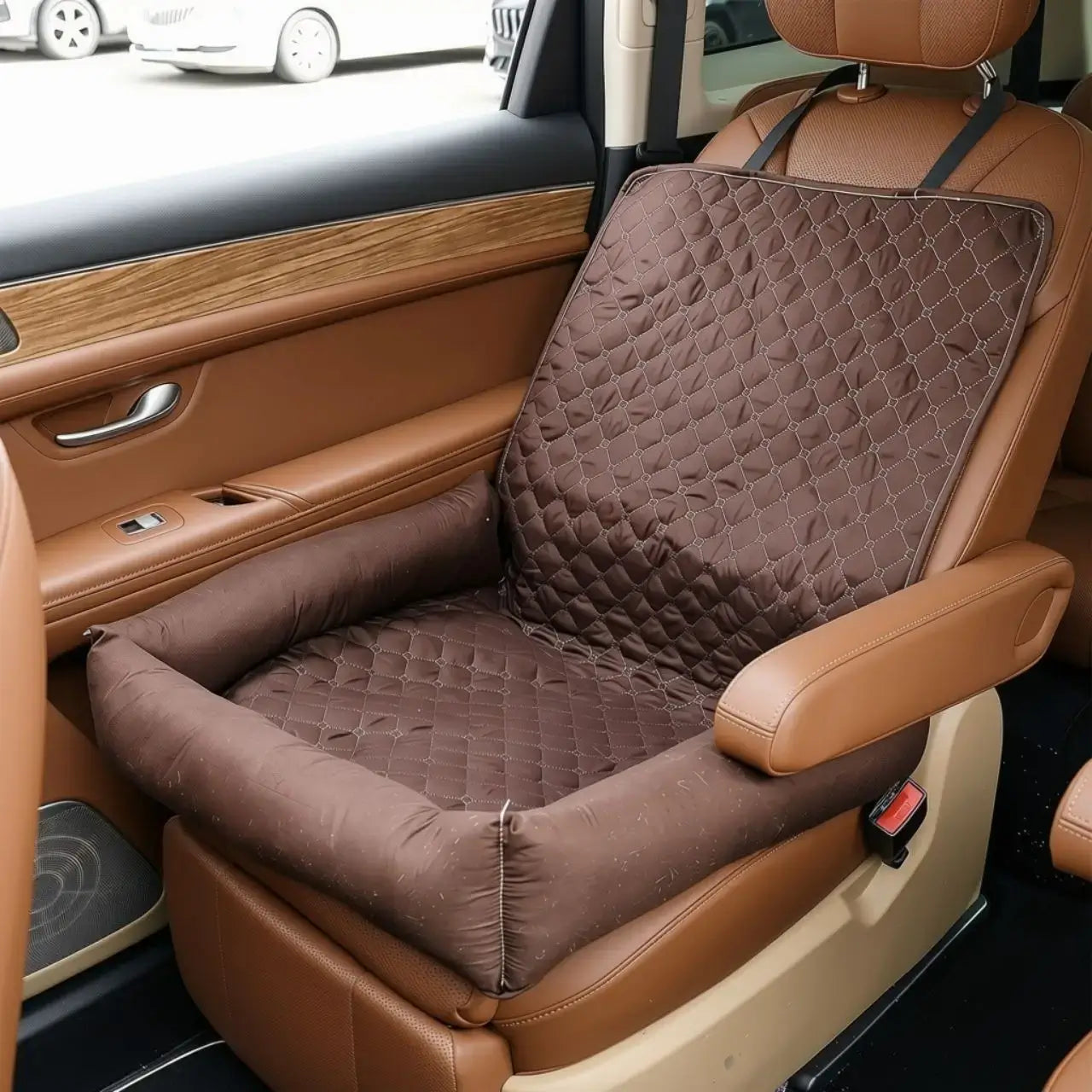 Un coussin pour chien de voiture marron sur le siège avant.