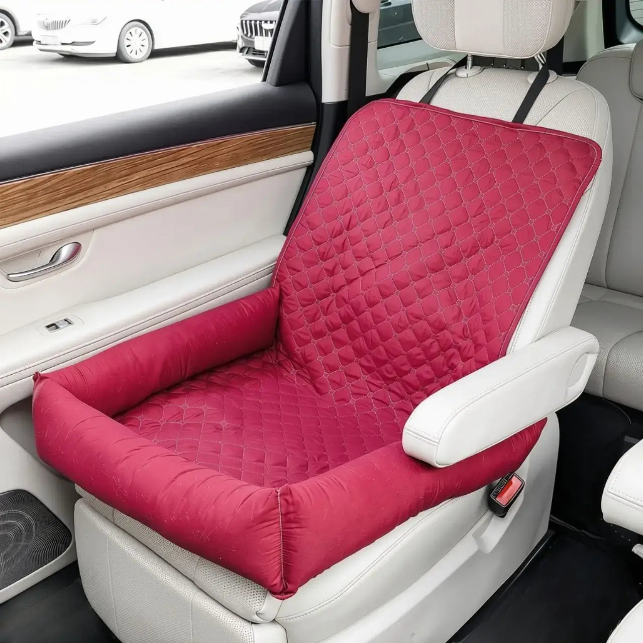 Un coussin pour chien de voiture rouge sur le siège avant.