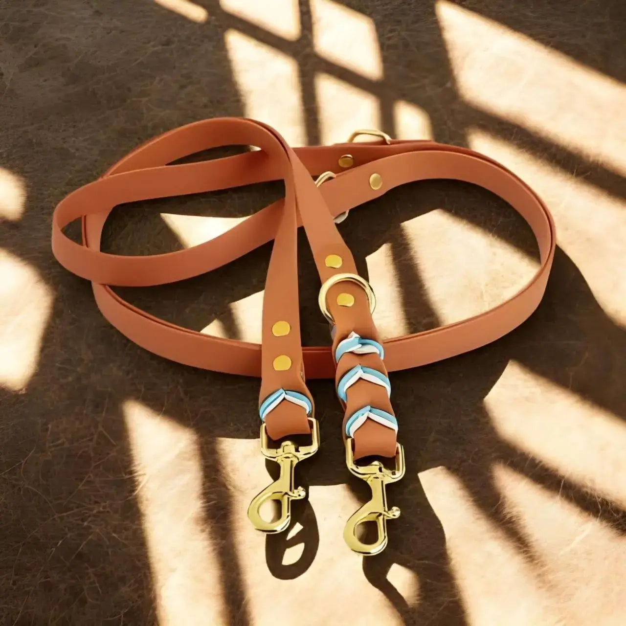 Une double laisse pour chien multifonctionnelle de couleur marron.