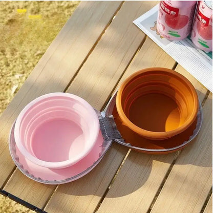 Une gamelle pour chien rose et marron sur une table en camping.