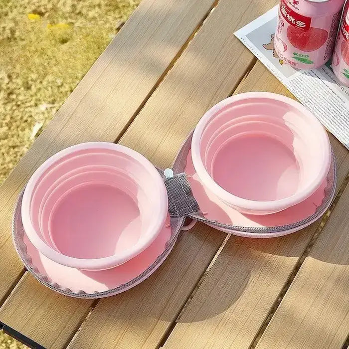 Une gamelle pliable pour chien rose sur une table.