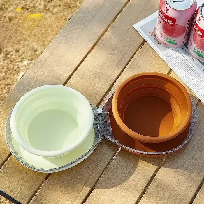 Une gamelle pliable pour chien turquoise et marron sur une table en camping.