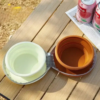 Une gamelle pliable pour chien turquoise et marron sur une table en camping.
