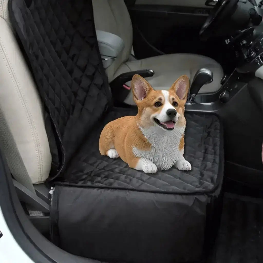 Un corgi allongé sur la housse de protection pour chien de voiture noire.