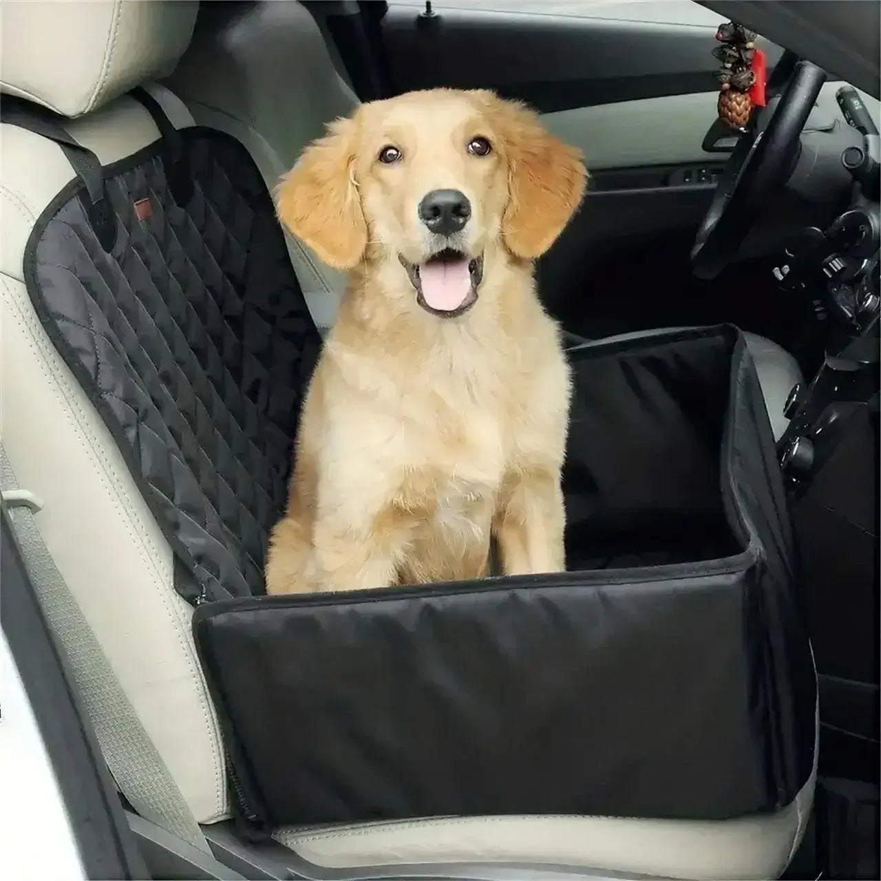 Un chiot labrador assis sur le siège avant dans la housse de protection pour chien de voiture.