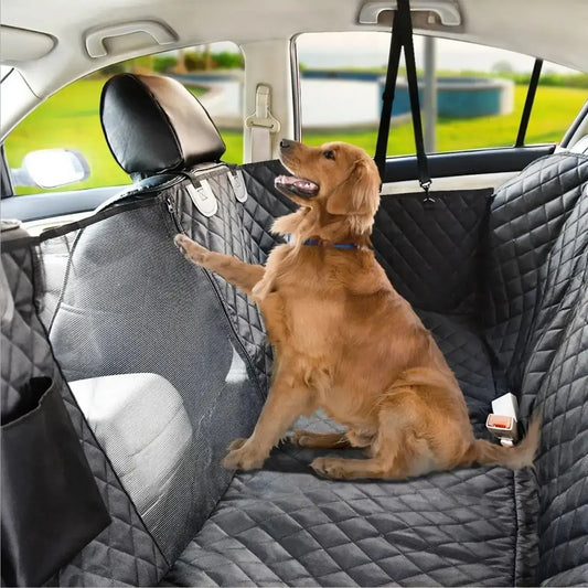 Un golden retriever assis sur la housse de voiture pour chien noir sur la banquette arrière d'une voiture.