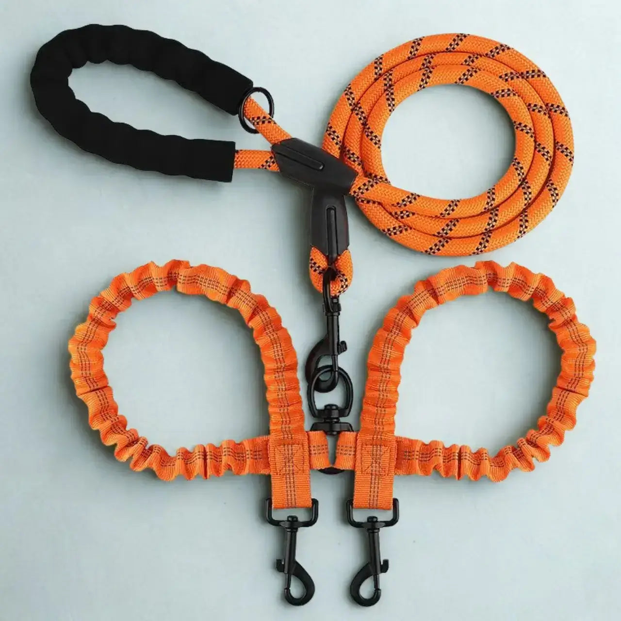 Une laisse double pour chien de couleur orange.