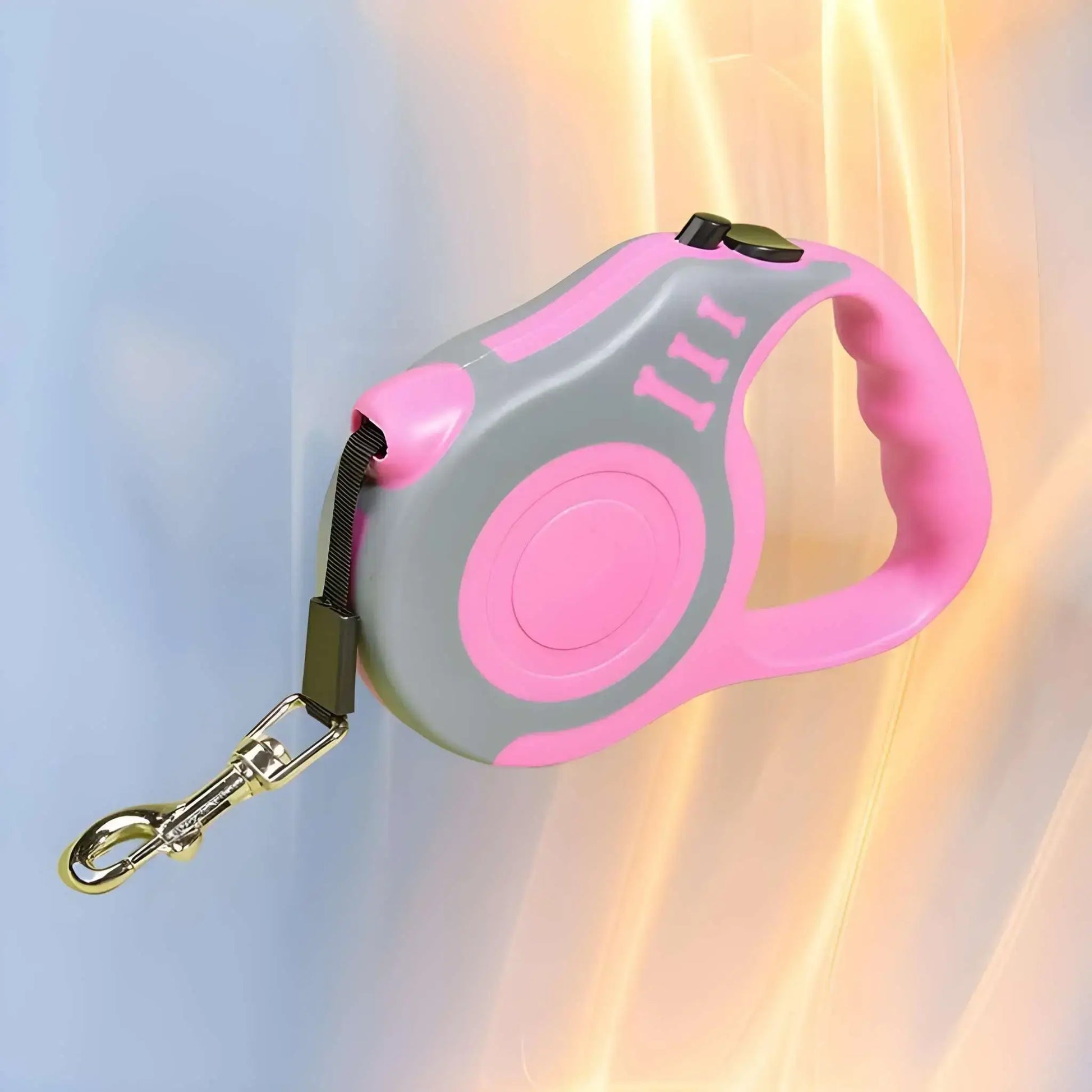 Une laisse enrouleur pour chien de couleur rose.