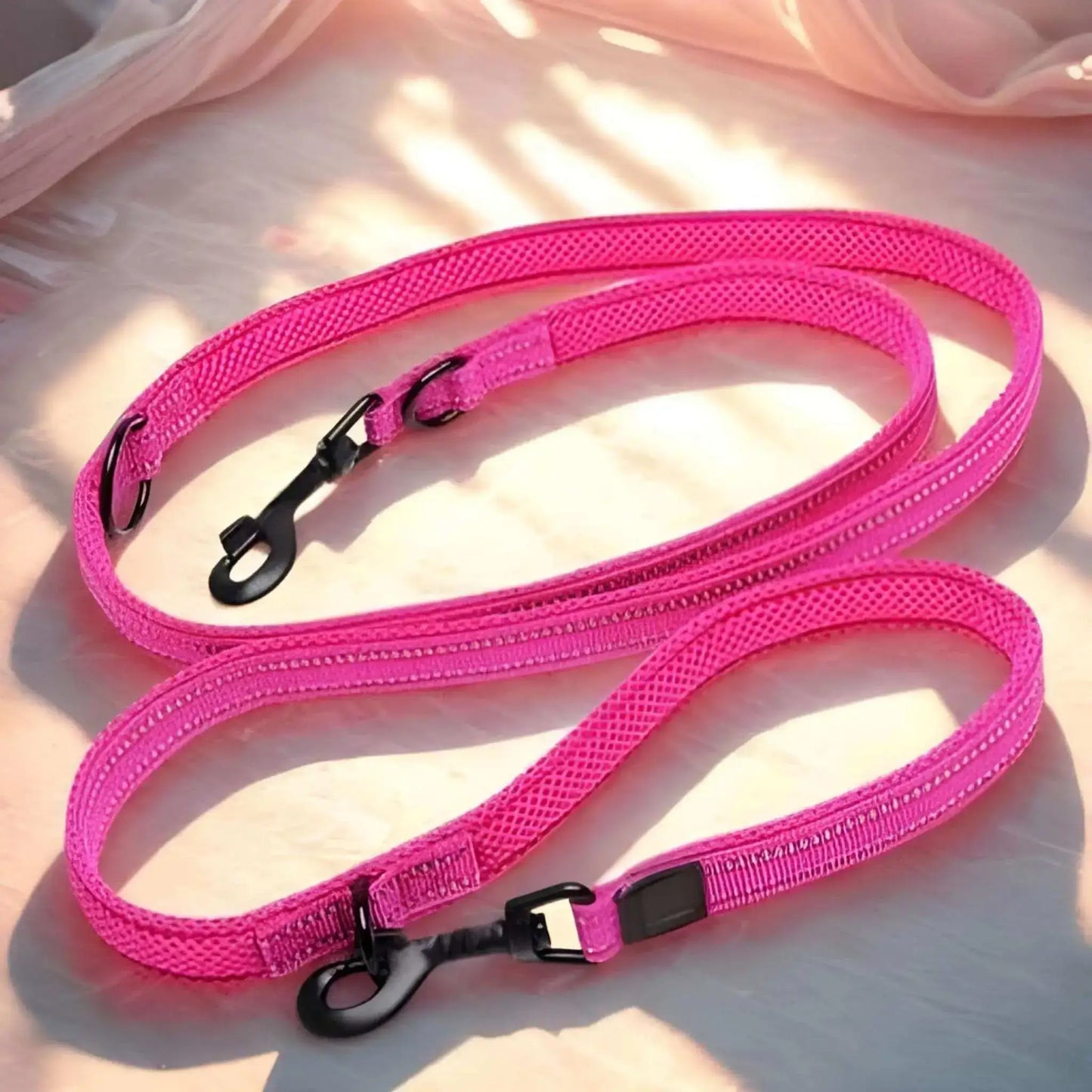 Laisse main libre pour chien au sol de couleur rose.