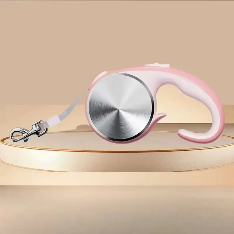 Une laisse pour chien rétractable de couleur rose.