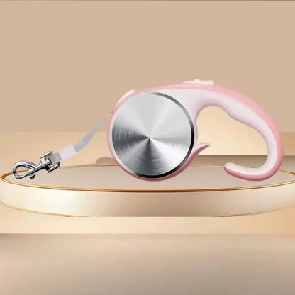 Une laisse pour chien rétractable de couleur rose.