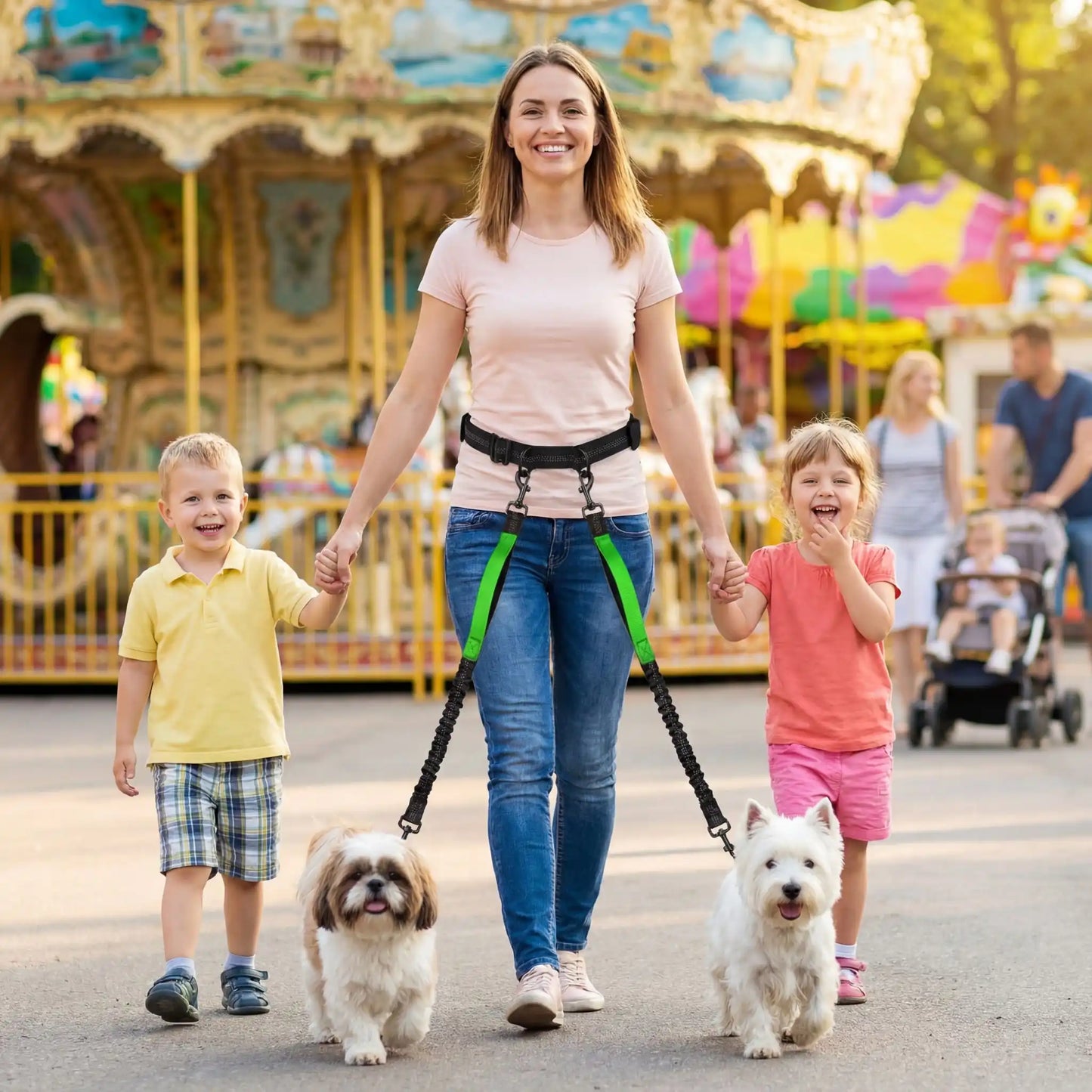 Une femme tient ces deux enfants par la main dans une fête foraine avec une laisse pour chien main libre pour ses shih tzu.