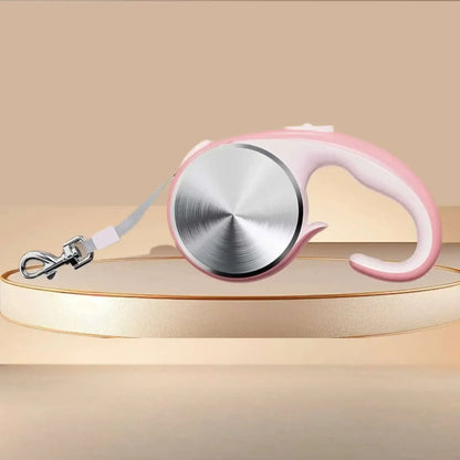 Une laisse pour chien rétractable de couleur rose.