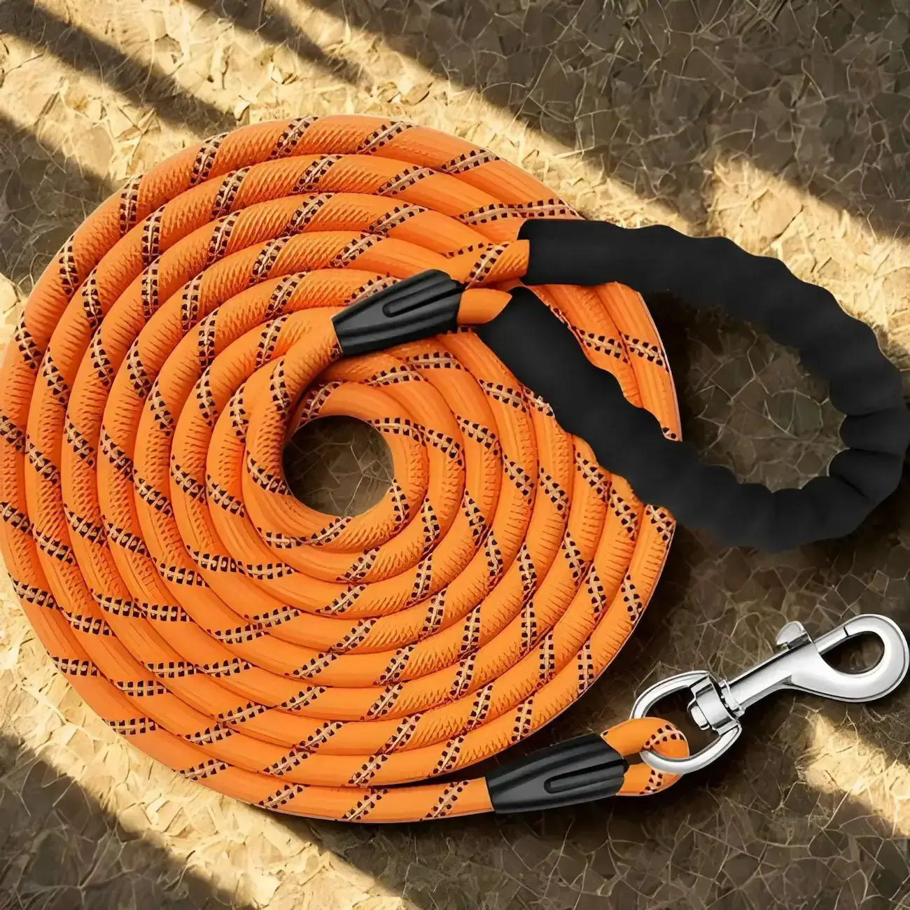Une longe pour chien orange avec poignée rembourrée.
