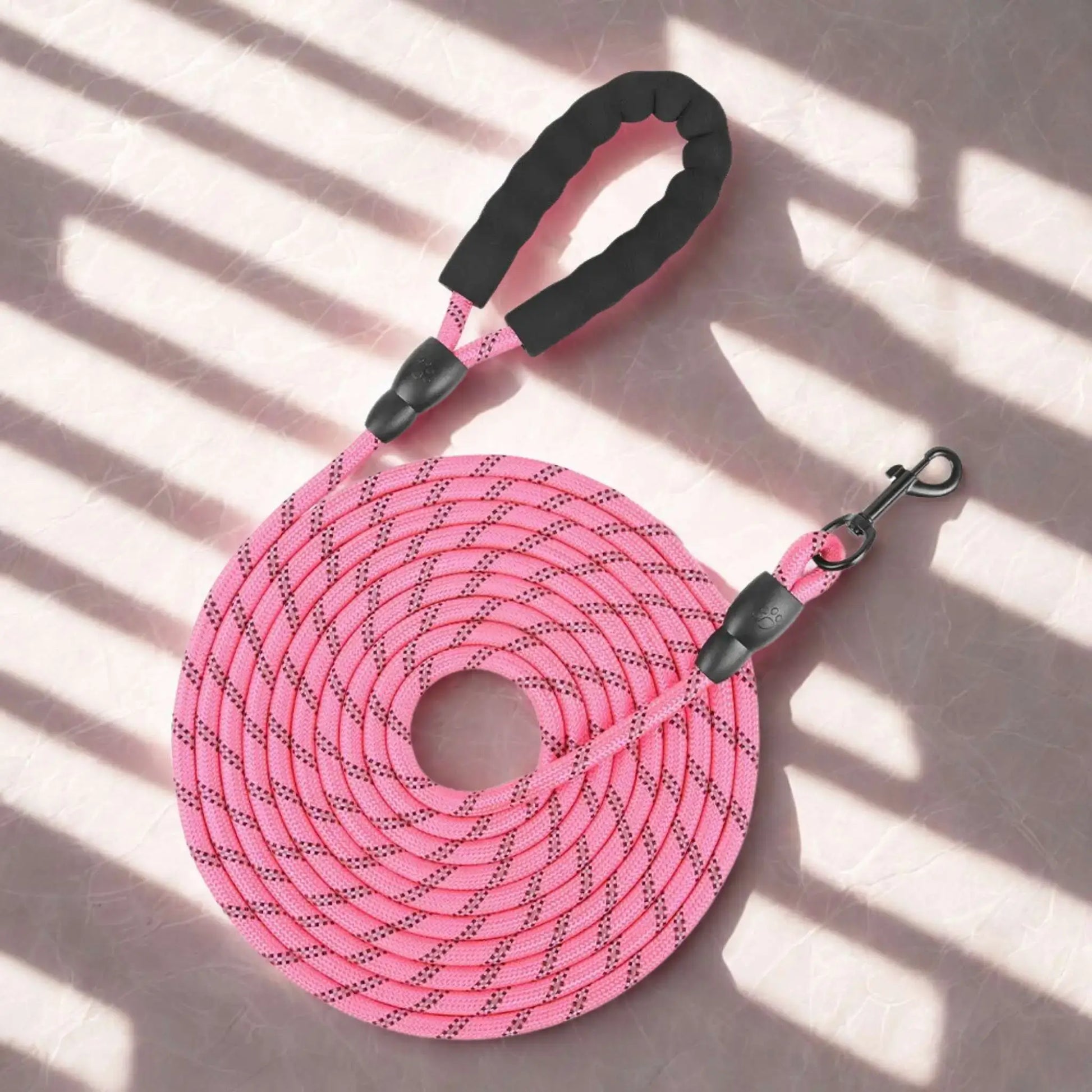 Une longe pour chien de couleur rose avec poignée rembourrée.