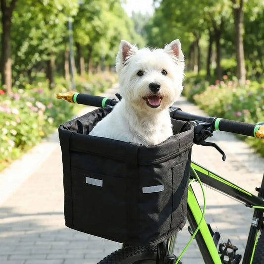Un west highland assis dans un panier de vélo pour chien noir.