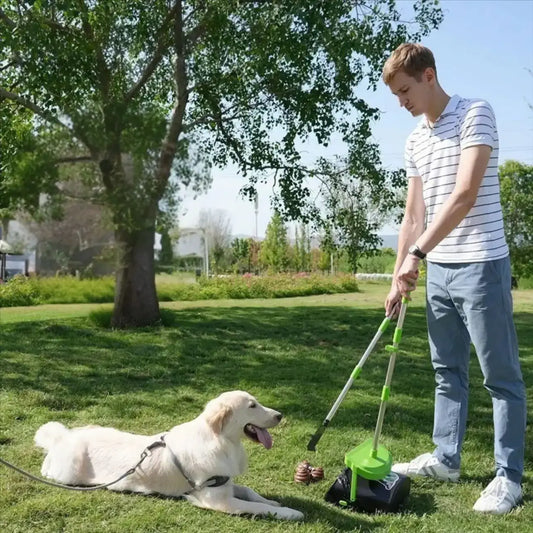 Un homme ramasse les crottes de son labrador dans un parc avec la pelle à crottes pour chien.