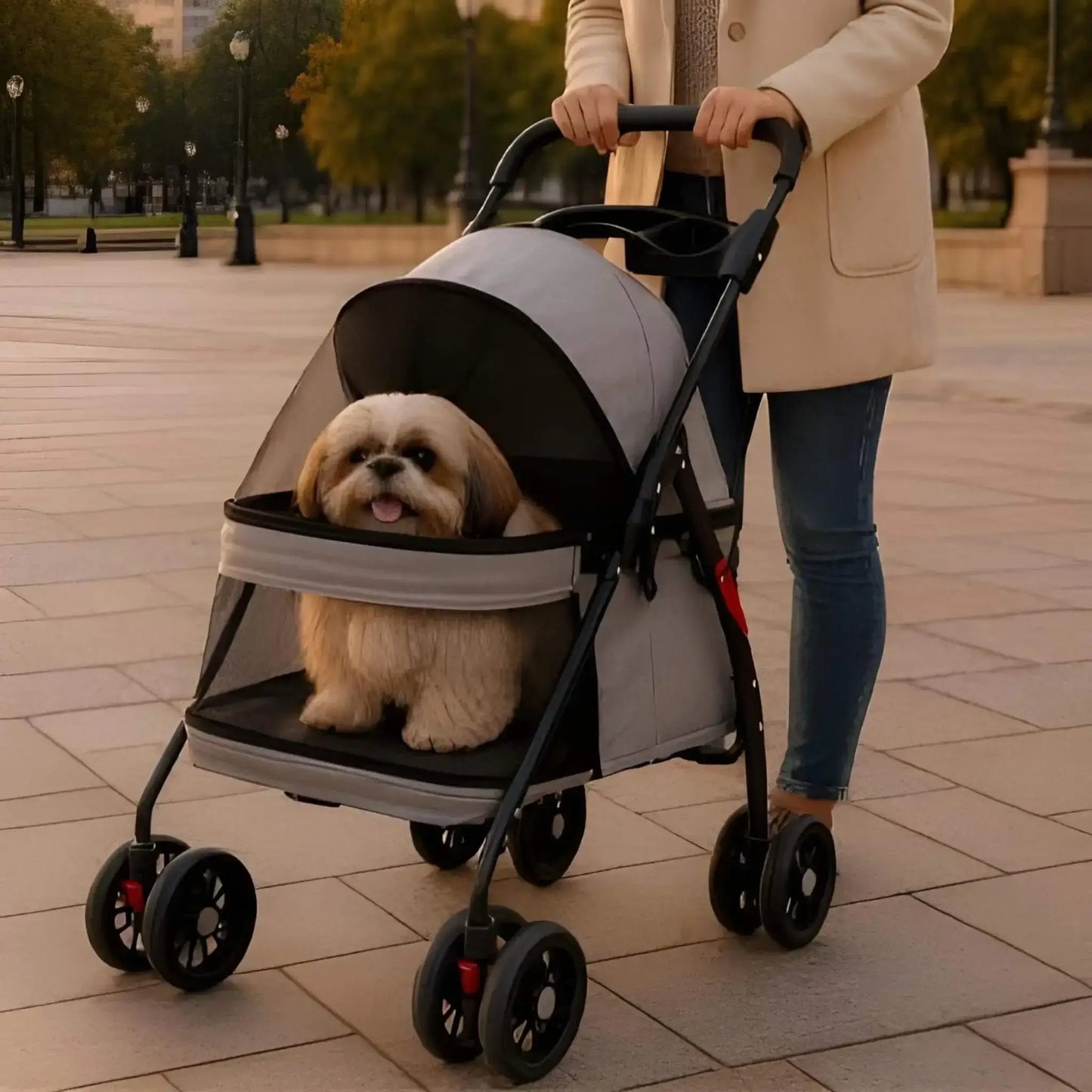 Une femme avec un shih tzu dans une poussette pour chien grise sur un trottoir dans un parc