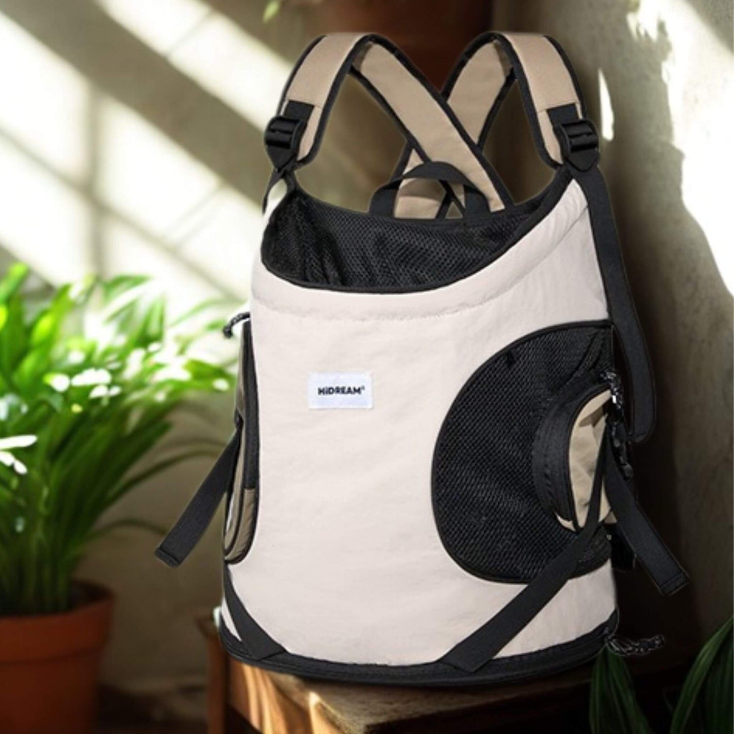 Un sac à dos beige sur une chaise avec plante sur le côté