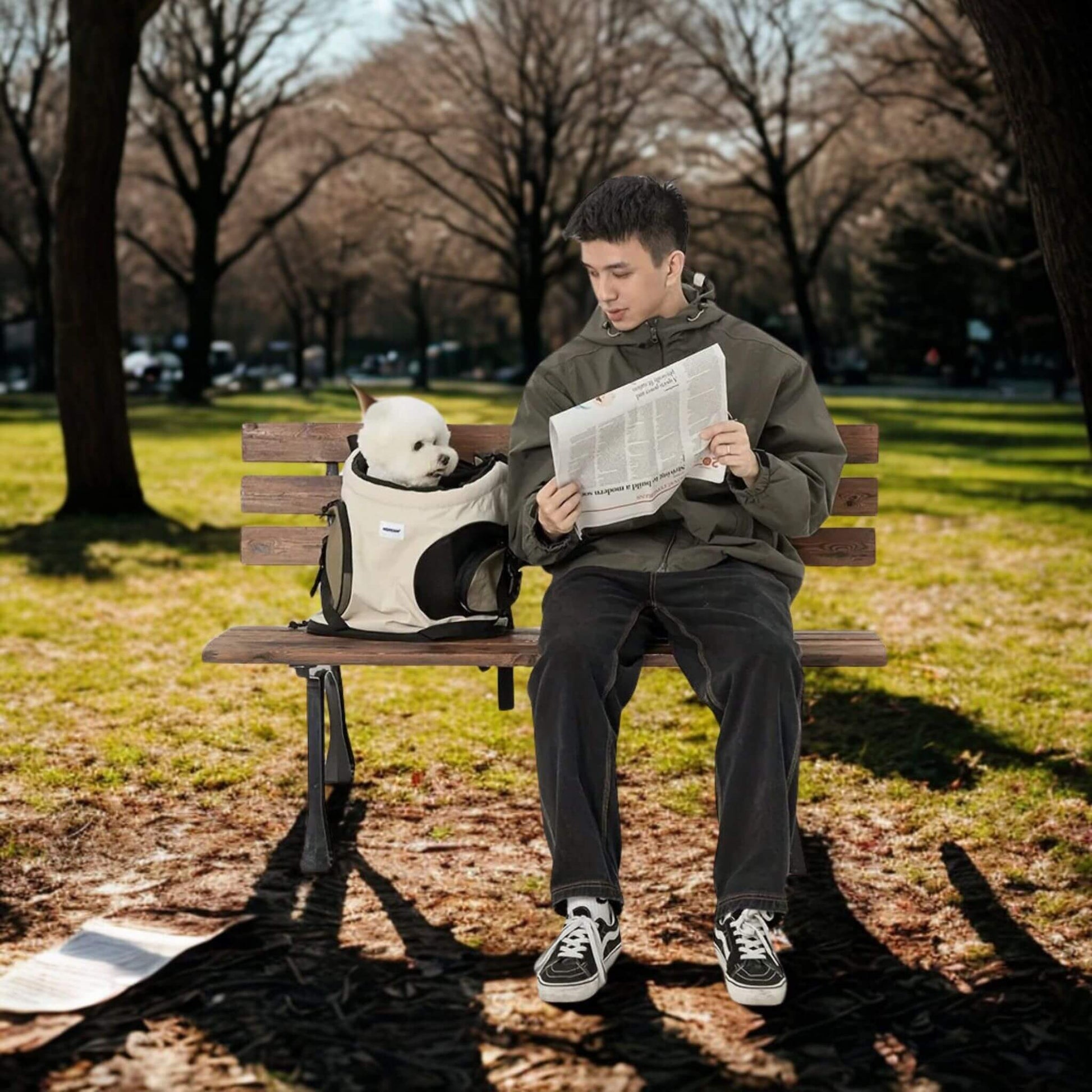 Homme sur un banc de parc avec son caniche dans son sac à dos pour chien regardant son journal