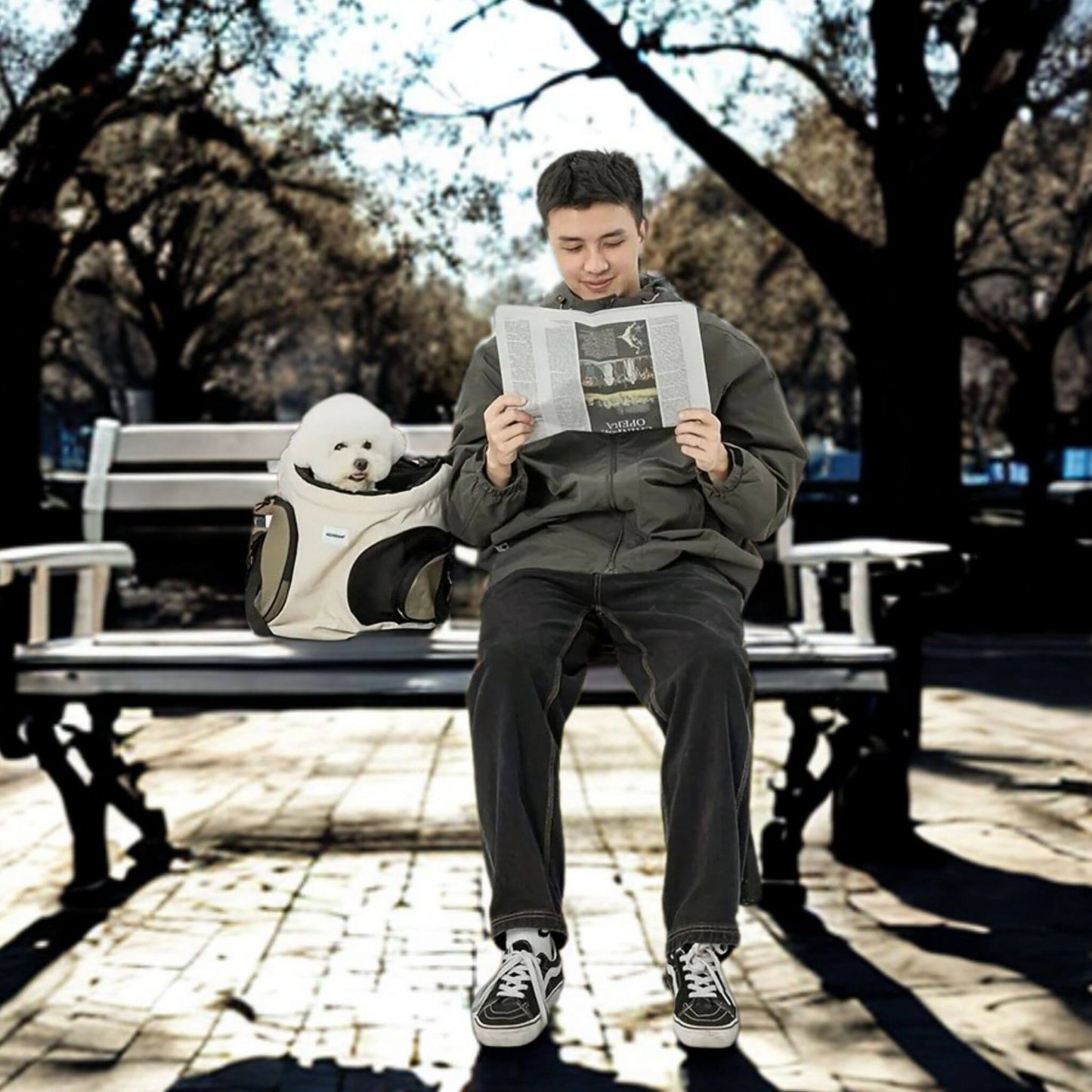 Un homme sur un banc de parc avec son sac à dos pour chien, lisant un journal.