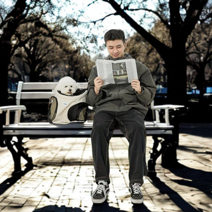 Un homme sur un banc de parc avec son sac à dos pour chien, lisant un journal.