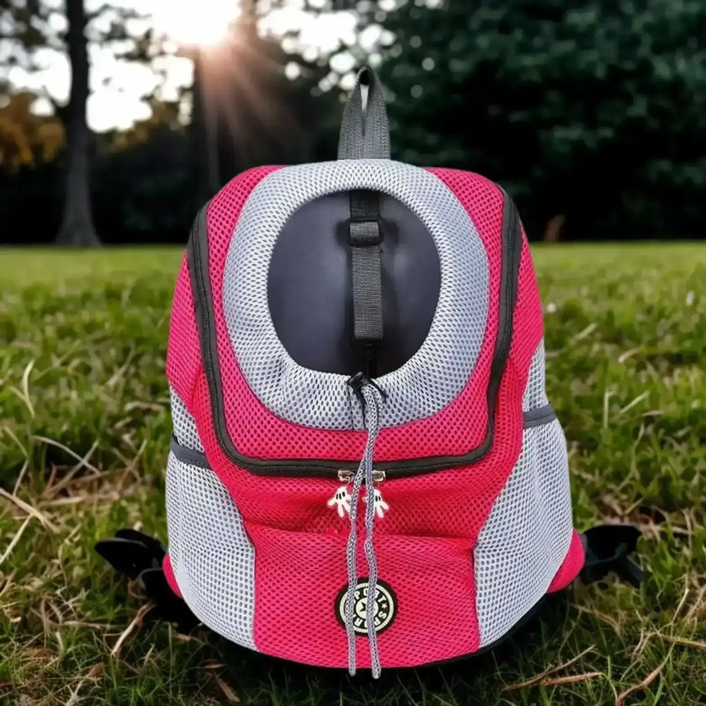 Un sac à dos pour chien de couleur rouge sur une pelouse.