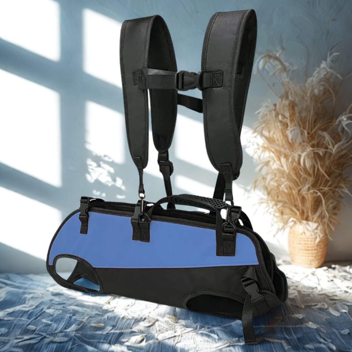 Un sac à dos bleu porté deux sangle à l'épaule sur un tissu bleu et plante sèche en arrière