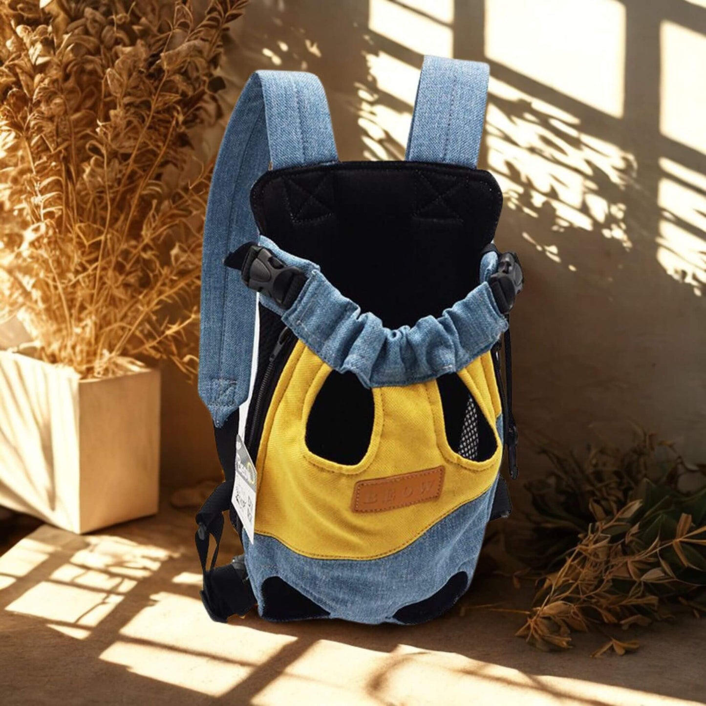 Un sac à dos pour chien bleu et jaune avec plante sèche en décoration
