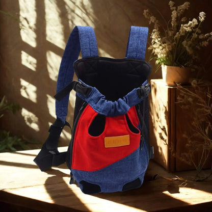 Un sac à dos pour chien bleu et rouge sur une table de bois avec plante séchée.