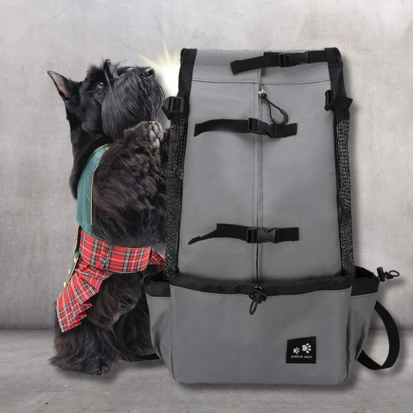 Un sac à dos gris avec un scotch terrier noir sur ses pattes arrière avec une jupe écossaise.